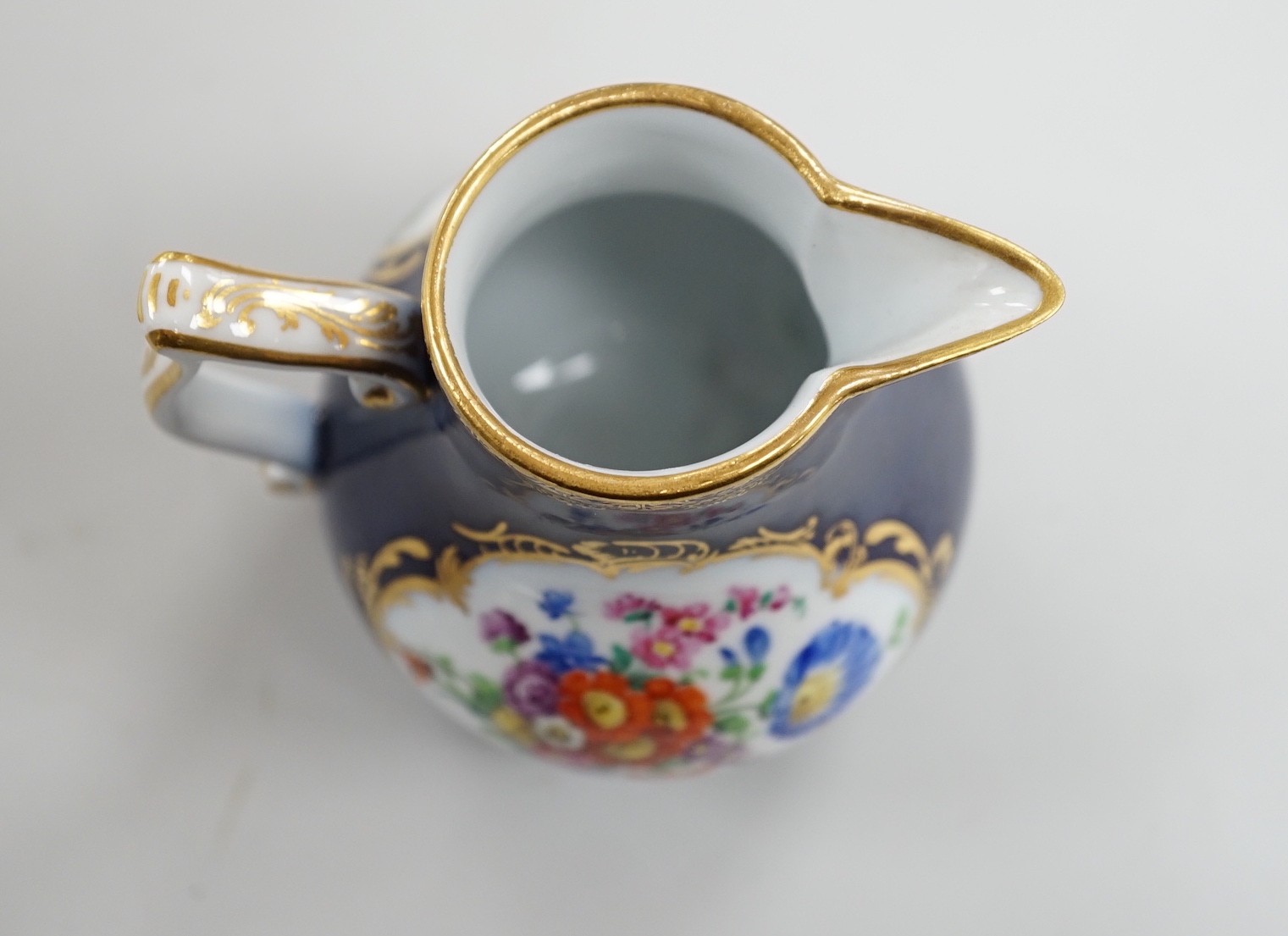 A small 19th century Meissen cobalt blue ground jug and cover, 9.5cm tall